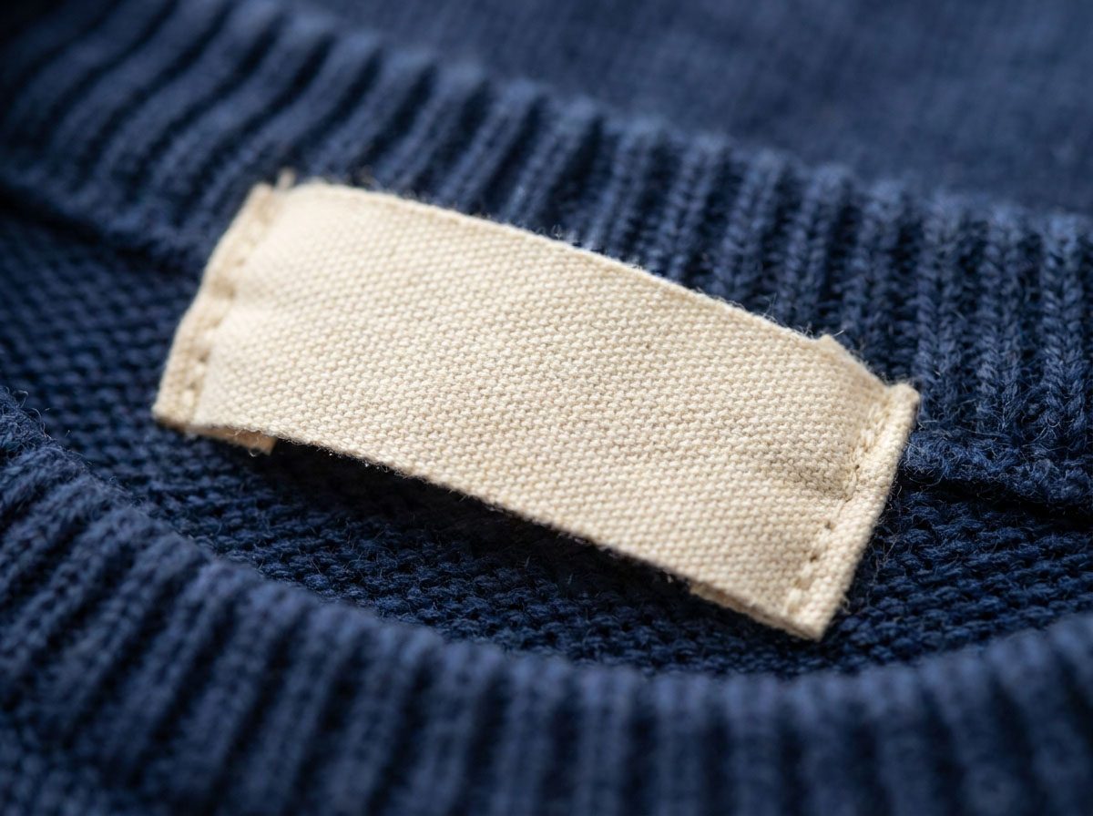 Custom school uniform labels woven in soft cotton and sewn into a child's sweater neck